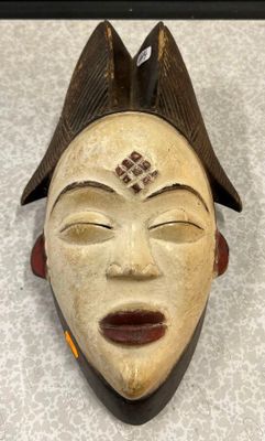 une image représentant un masque en bois surmonté d'un oiseau