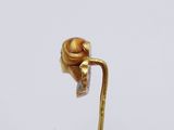 a close up of a gold flower on a stick