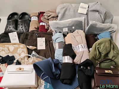 un tas de vêtements et de sacs sur un lit