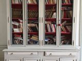 a white bookcase with many books on top of it