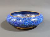 a close up of a blue and gold bowl on a table