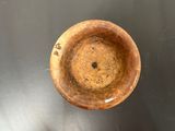 a wooden bowl sitting on a table with a black background