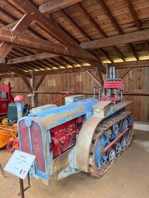 un vieux tracteur qui est garé dans une grange