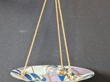 a close up of a plate hanging from a rope on a wall