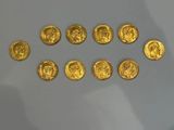 several gold coins sitting on top of a table next to each other