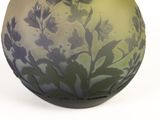 a vase with a butterfly on it sitting on a table