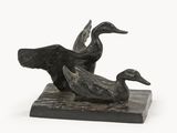 a statue of two ducks sitting on a marble block