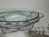 a glass bowl on a metal stand next to a wire rack