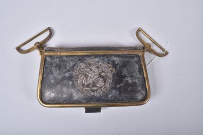 an old purse with a lion on it sitting on a white surface