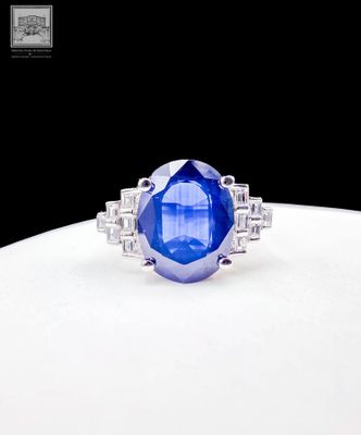 gros plan d'une bague en saphir bleu et diamant sur une surface blanche