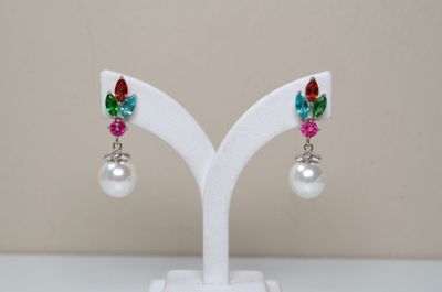 pair of multicolored crystal and pearl earrings on a white stand