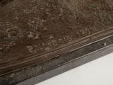 a bronze statue of a bird on a table