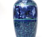 a blue vase that is sitting on a white surface