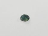 a green tourmaline stone on a white surface