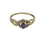gros plan d'une bague en or avec une pierre bleue