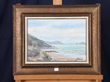 une peinture à l'huile représentant une scène de plage, posée sur un chevalet, avec un fond bleu