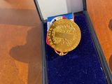 a gold medal sitting in a blue box on a table