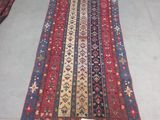 a red and blue rug with a pattern of flowers on it