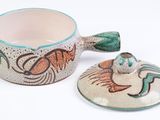 a bowl with a lid that has a fish design on it