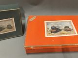 two boxes with pictures of trains on them sitting on a table