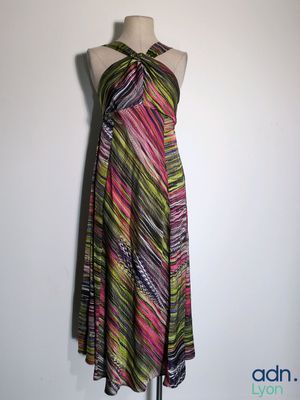 a woman ' s dress on a mannequin stand against a wall