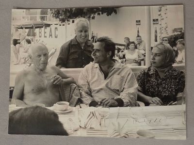 une photo en noir et blanc d'un groupe de personnes assises à une table