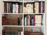a book shelf with many books on it in a room