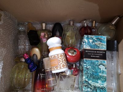 plusieurs flacons de parfum dans une boîte posée sur la table