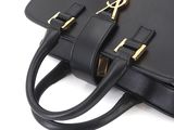 a black handbag with gold hardware on the handles