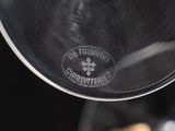 a close up of a wine glass with a wine bottle in the background
