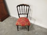 a small chair with a red seat in the corner of a room