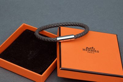 an orange box with a bracelet inside of it on a gray surface