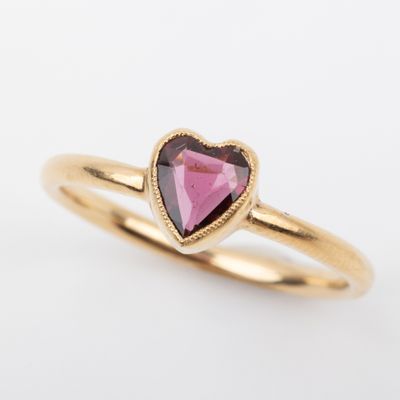 a gold ring with a heart shaped pink tourmaline stone