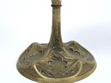 a gold cup on a stand on a white surface