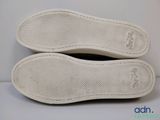 the soles of a pair of white shoes on a white surface