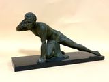 statue en bronze représentant une femme à genoux, posée sur un socle en marbre noir
