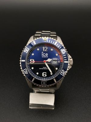 un gros plan d'une montre montée sur un bracelet en métal, posée sur une surface noire