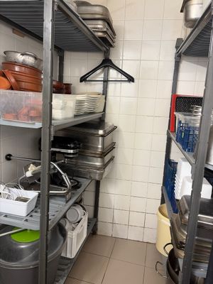 many pots and pans on the shelves in the kitchen