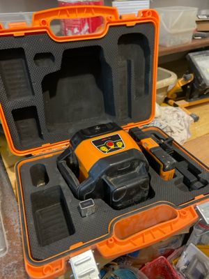une mallette à outils orange et noire posée sur une table en bois