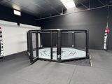 a cage in the middle of a gym with a punching bag