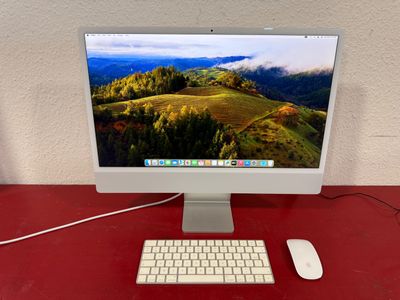 a computer on a red desk with a keyboard and mouse