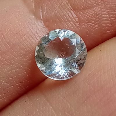 un gros plan sur la main d'une personne tenant un diamant bleu