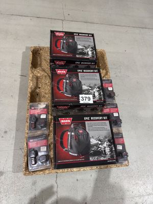 three boxes of black and red backpacks sitting on top of a pile of hay