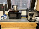 un micro-ondes et une cafetière posés sur le plan de travail d'une cuisine