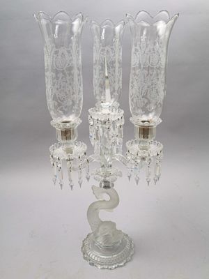un chandelier en verre surmonté de trois bougies