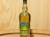 une bouteille de Chartreuse posée sur un tonneau