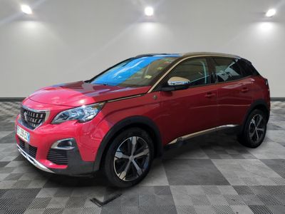 une voiture rouge est garée dans une pièce au sol en damier