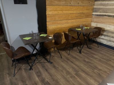 des tables et des chaises dans un restaurant aux murs et au sol en bois