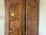 a large wooden armoire in the corner of a room
