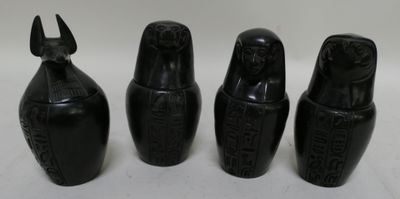 three black vases sitting next to each other on a white surface